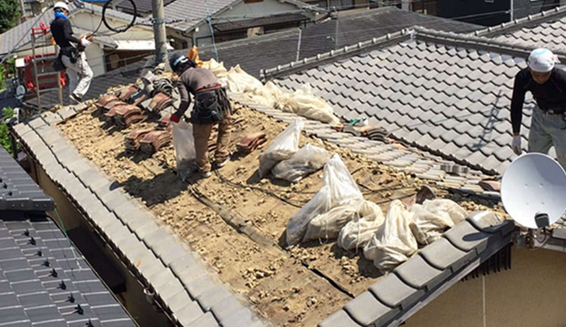 台風被害の屋根を修繕している写真